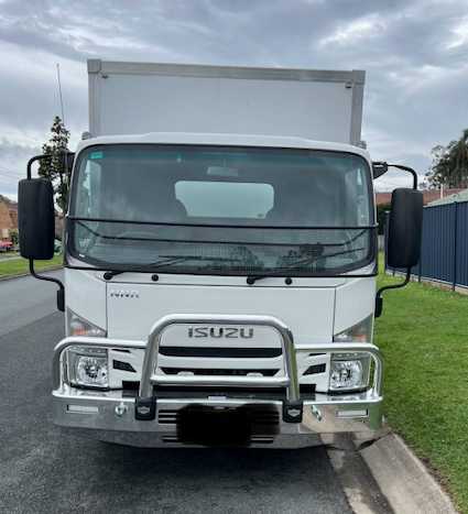 White Isuzu box truck parked beside a curb, front view under cloudy sky — Rob's Rubbish Removal in Byron Bay, NSW