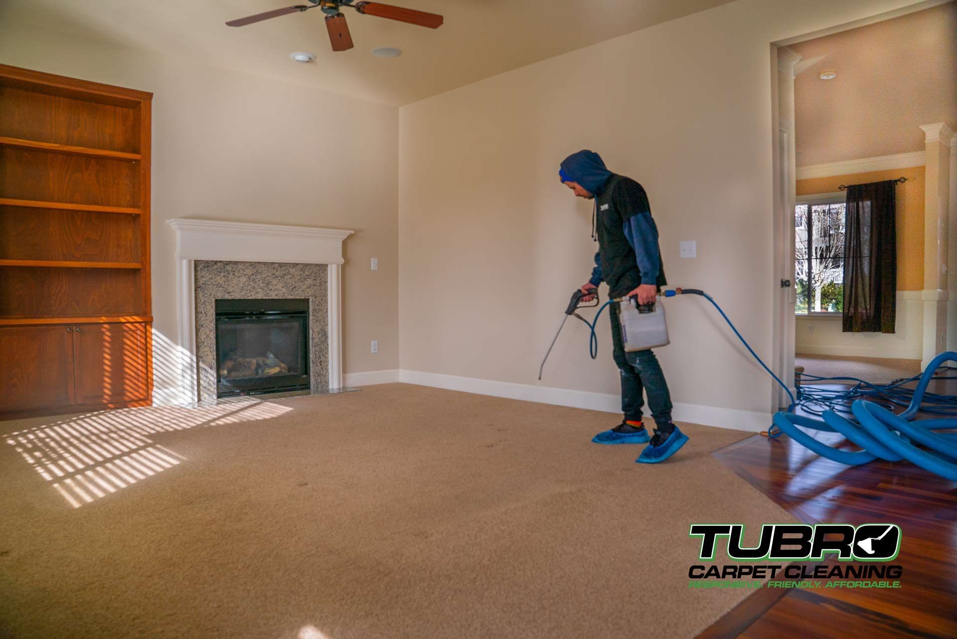 A man is cleaning a carpet in a living room.
