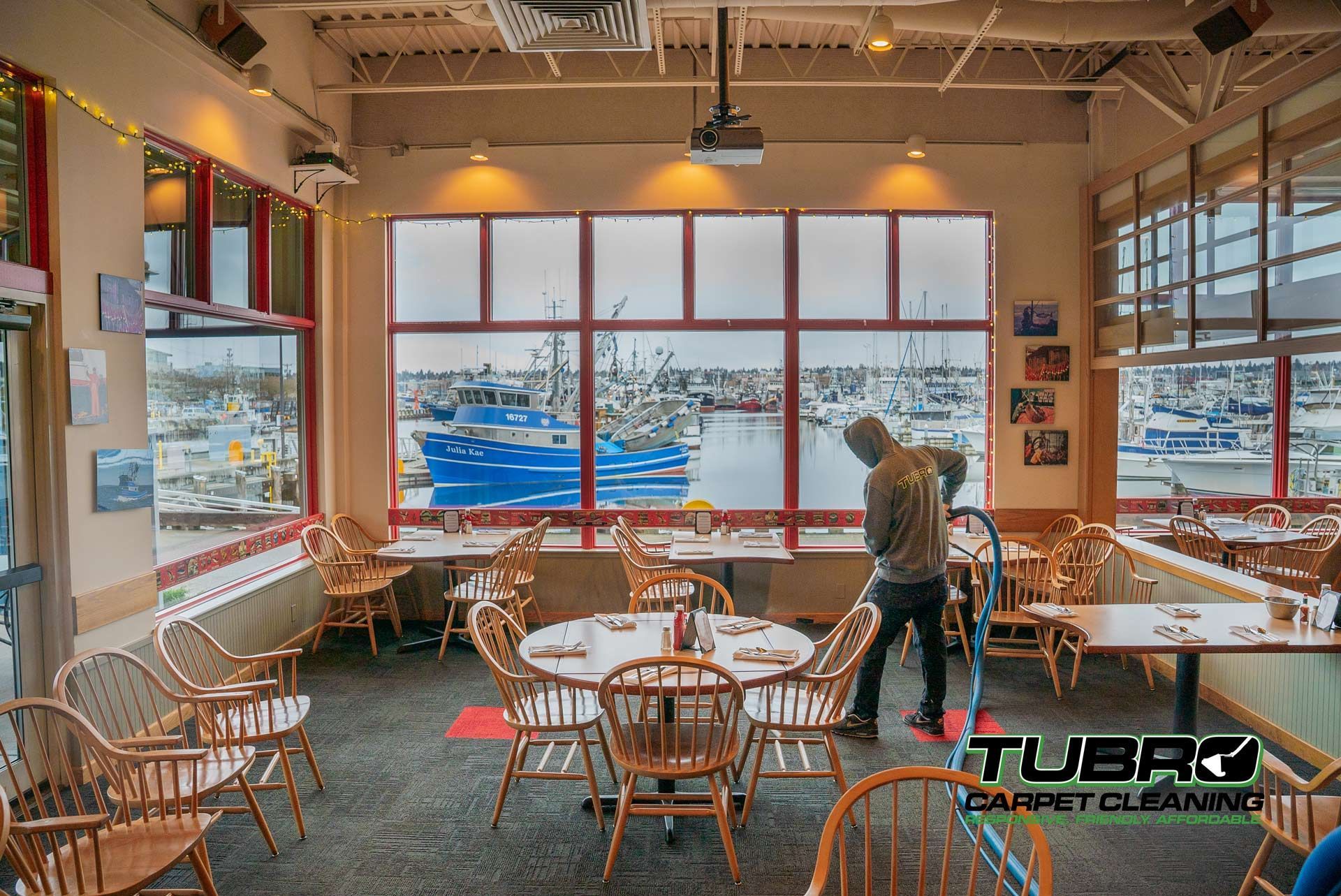 A man is cleaning tables and chairs in a restaurant.