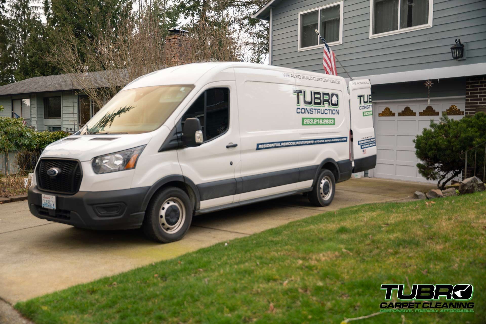 A white van is parked in front of a house.