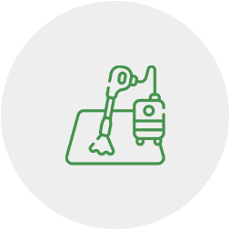 A green line icon of a vacuum cleaner on a mat.