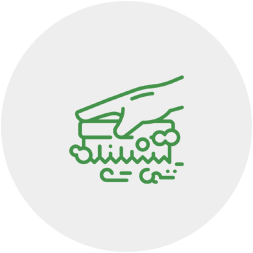 A green line drawing of a hand holding a pair of scissors.
