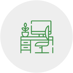 An icon of a desk with a chair and a computer on it.