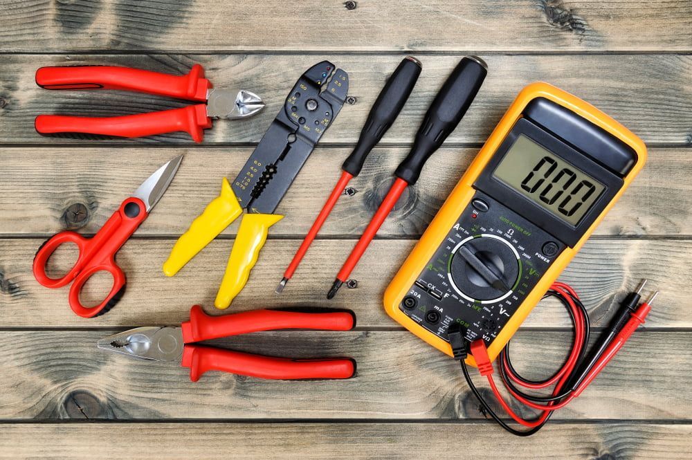 A Bunch of Electric Tools on a Wooden Table — East-West Fire Services In Garbutt, QLD