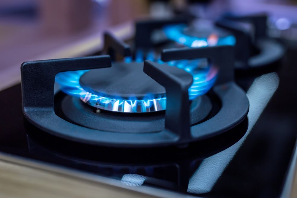 A Close Up Of A Gas Stove With A Blue Flame Coming Out Of It — East-West Fire Services In Garbutt, QLD