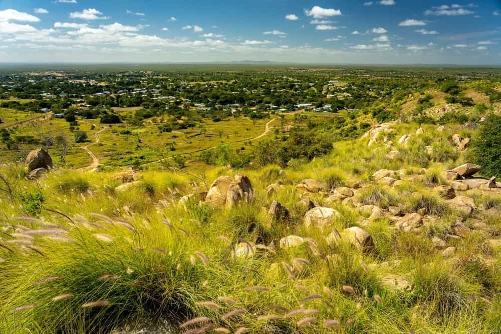 A View of a Lush Green Field With a Small Town in the Distance — East-West Fire Services In Charters Towers, QLD