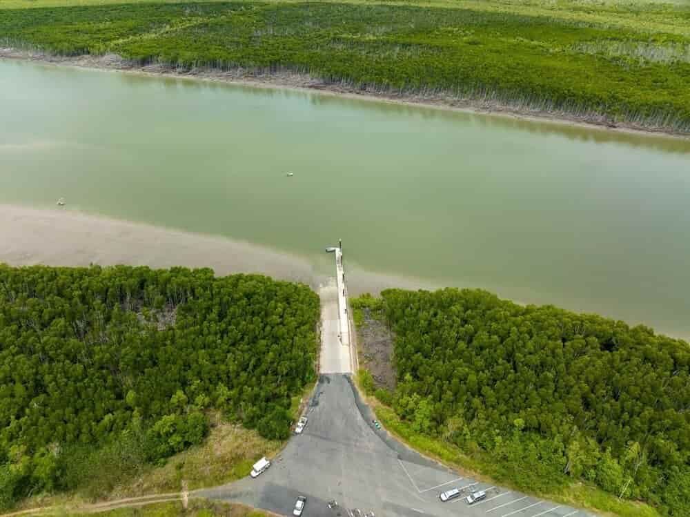 An Aerial View of a Road Leading to a Body of Water Surrounded by Trees — East-West Fire Services In Proserpine, QLD