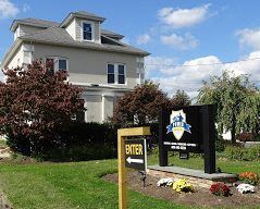 A two-story beige building with a sign that says 