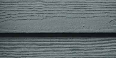 Close-up of dark gray siding with horizontal wood grain texture.