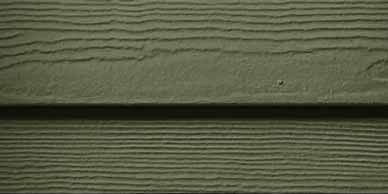 Close-up of olive green siding with horizontal grooves and a visible seam.