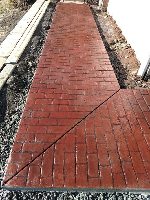 Red brick pattern concrete walkway leading to a corner.