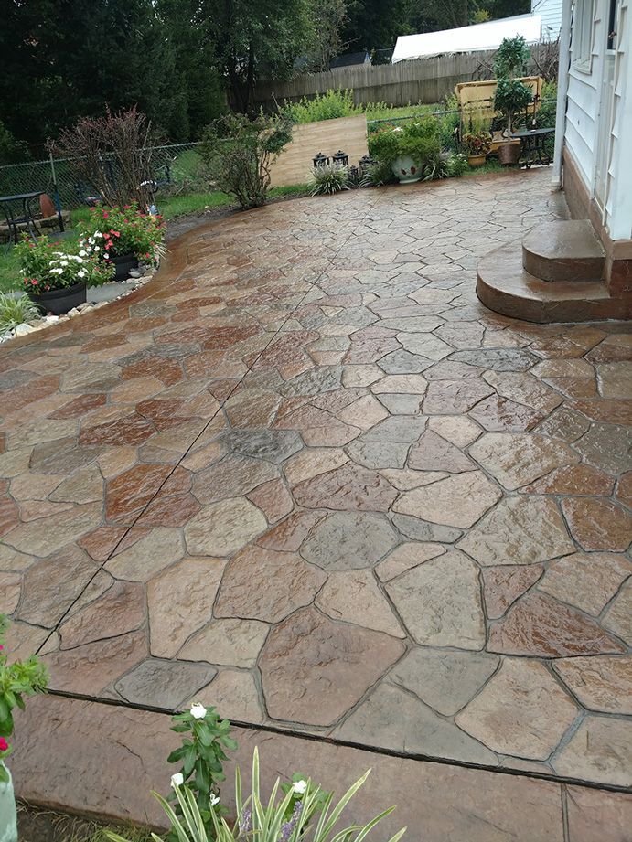 Stamped concrete patio with stone pattern in shades of brown.