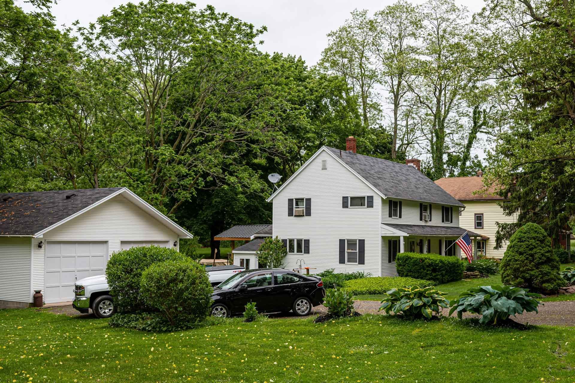 White house exterior with garage and trees, illustrating sustainable home upgrades
