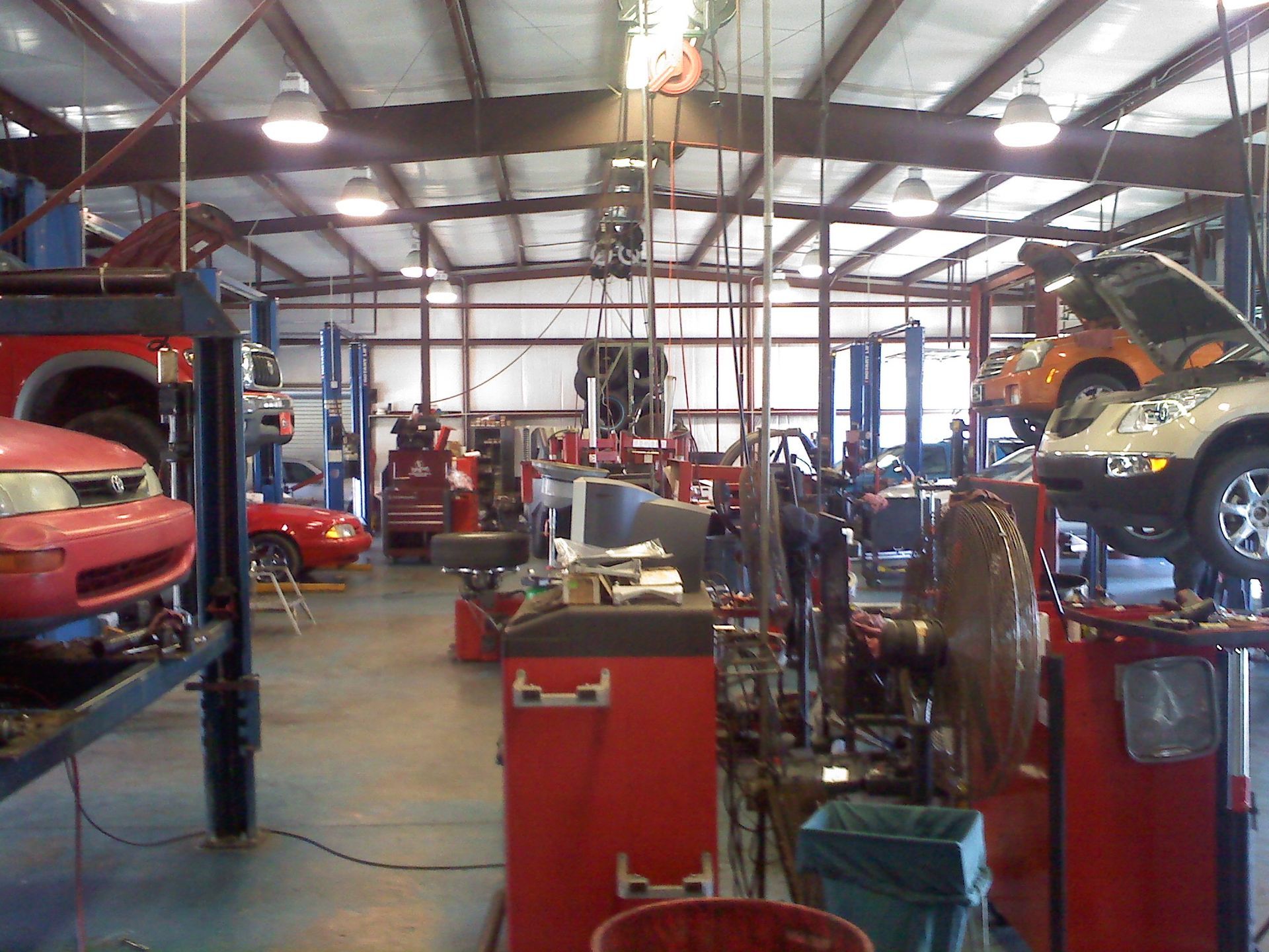 Interior View Of Auto Repair Shop With Vehicles On Lifts | C&C Tire Service