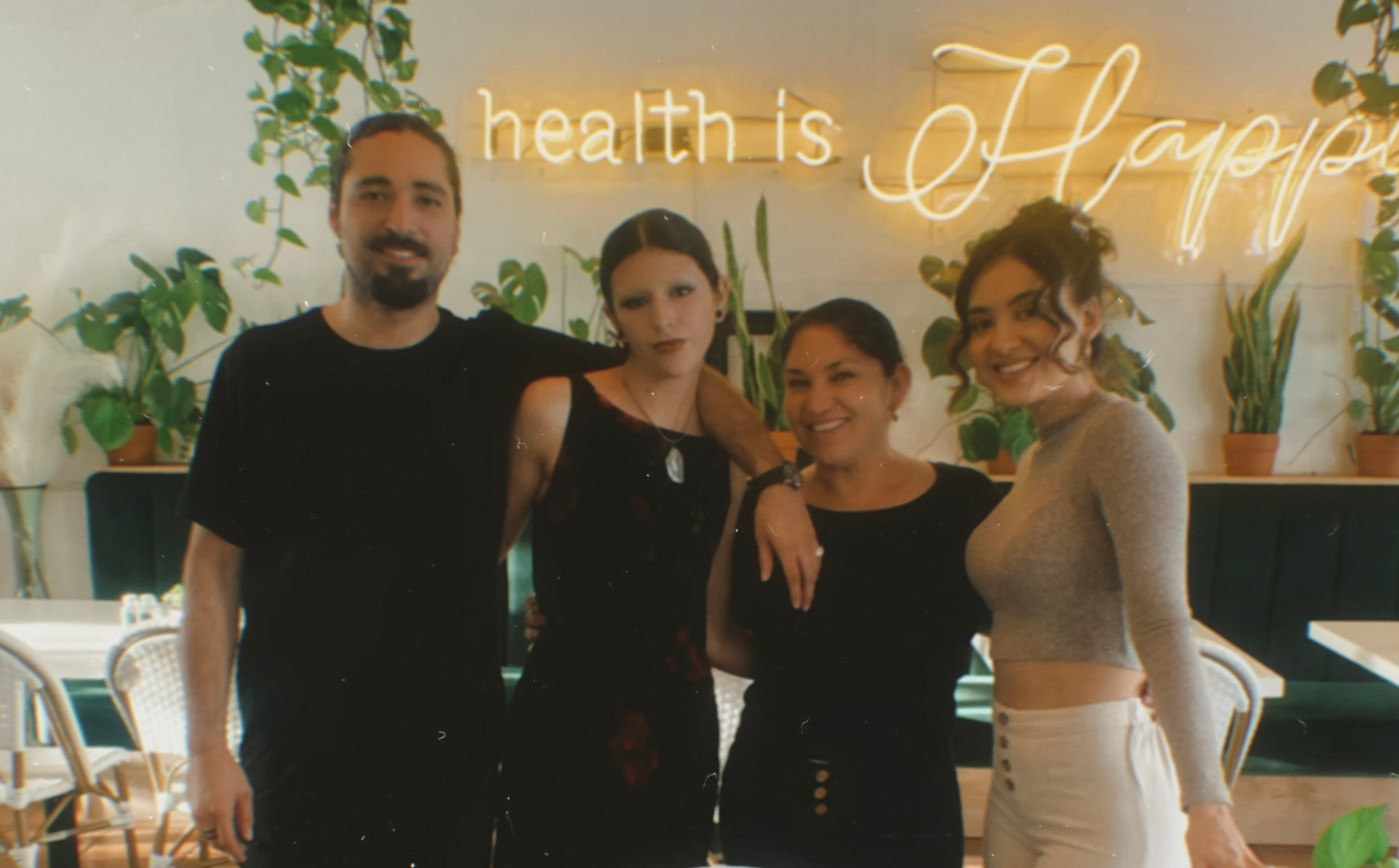 Four people pose together in a cafe. 