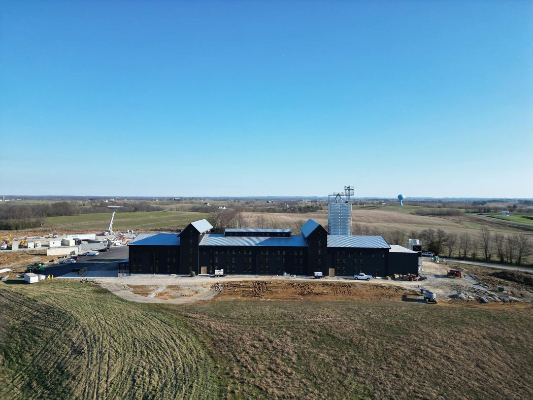 An aerial view of a large building in the middle of a field.