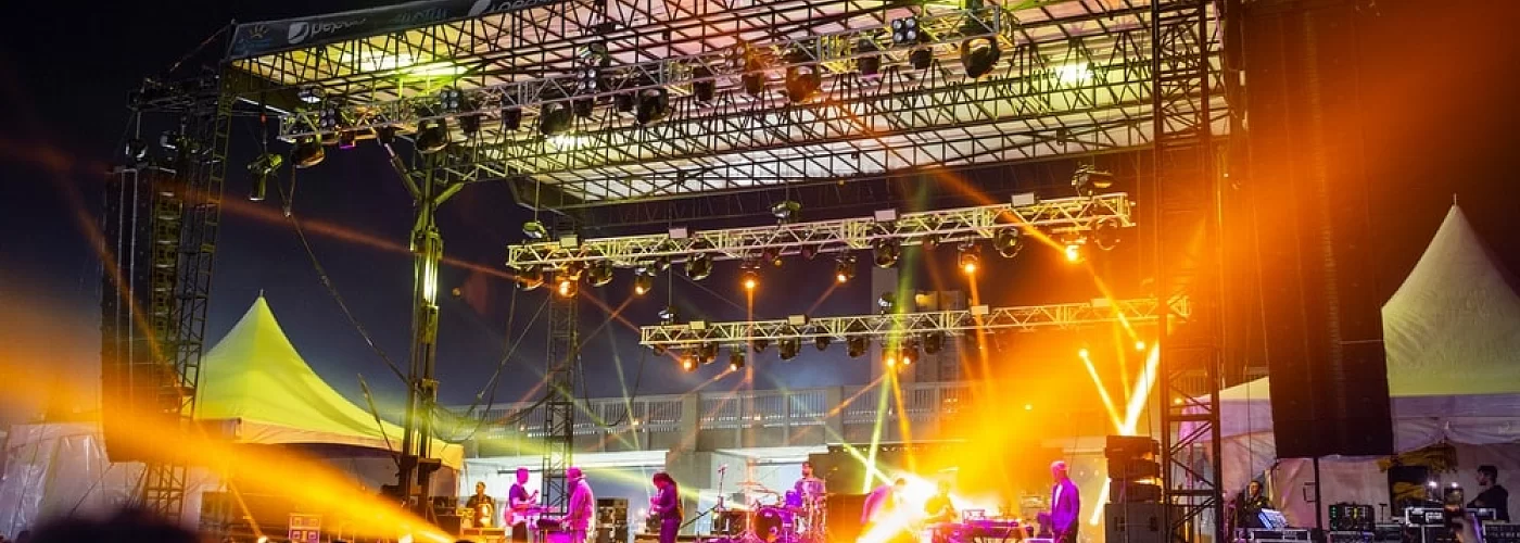 A group of people are standing on a stage at a concert.