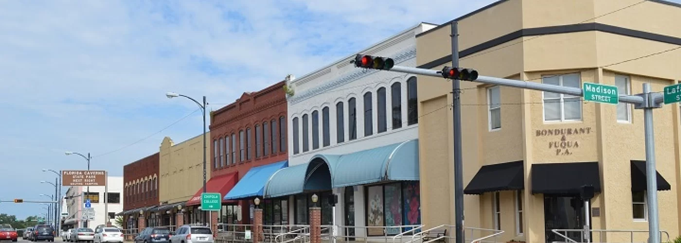 A row of buildings are lined up on the corner of a street.