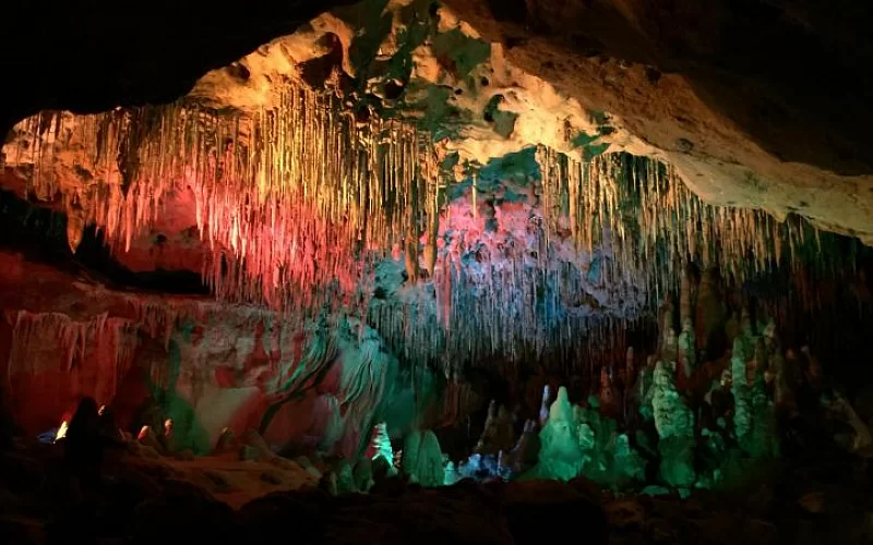 A cave with a lot of icicles hanging from the ceiling.
