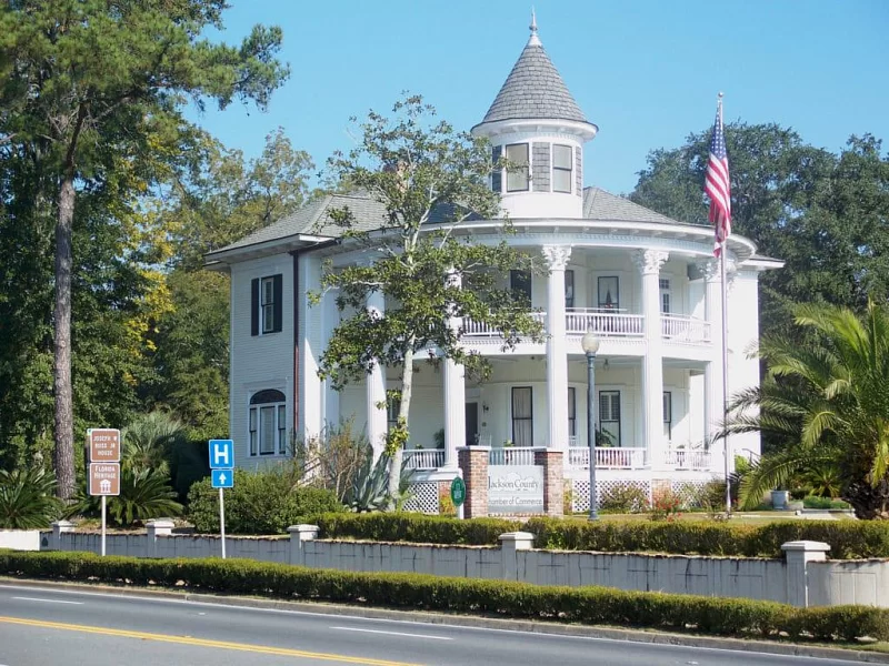 A large white house with a hospital sign in front of it