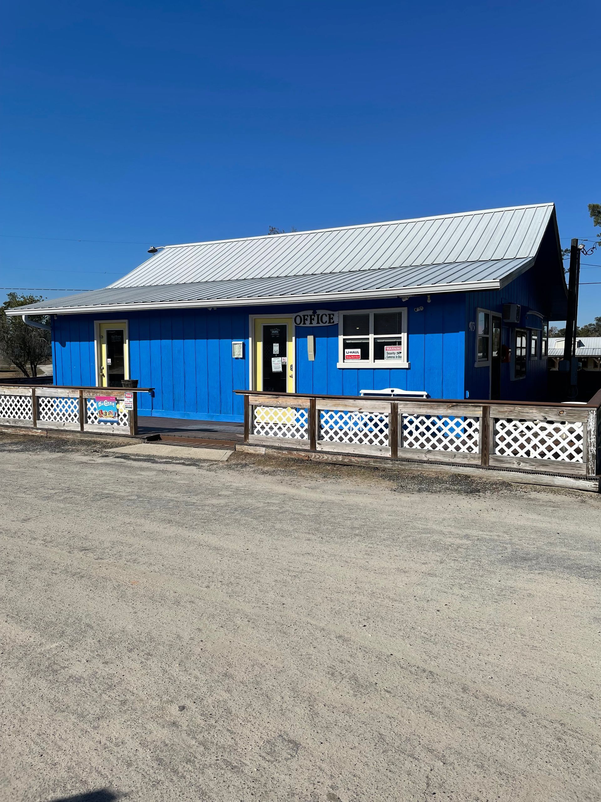 A blue house with a white roof and a white fence