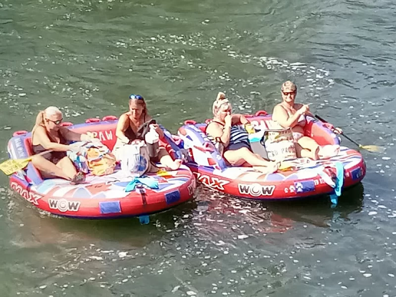 A group of people are floating on rafts that say wow