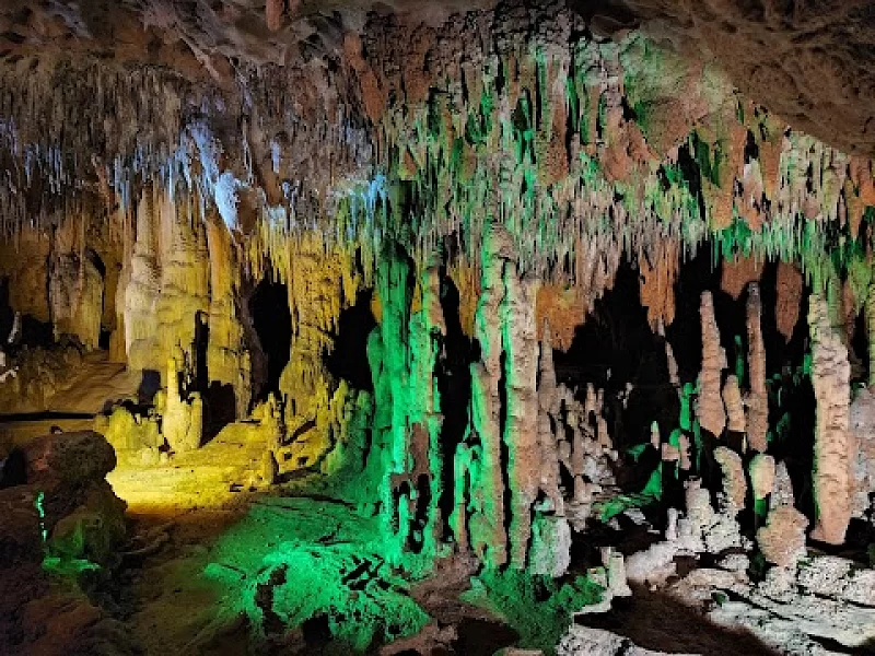 A person is standing in a cave with a light on.