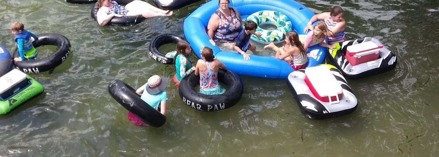 A group of people are floating on rafts in the water.