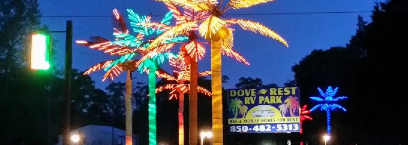 A sign for dove rest rv park is lit up at night