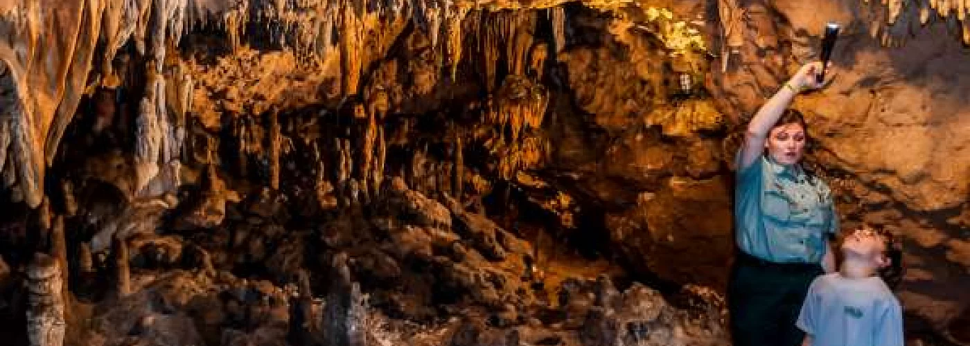 A man and a boy are standing in a cave.
