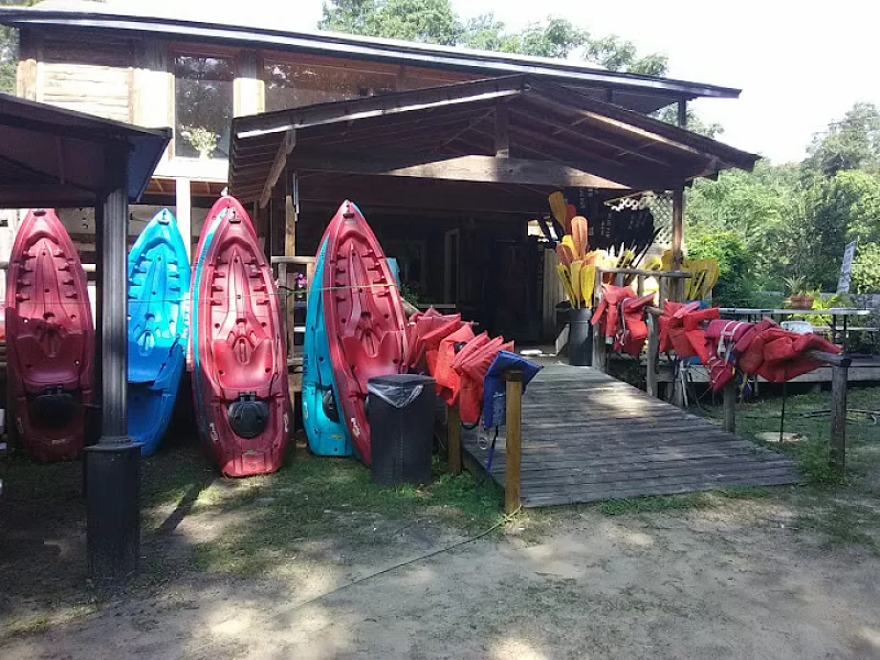 A row of kayaks are lined up in front of a building.