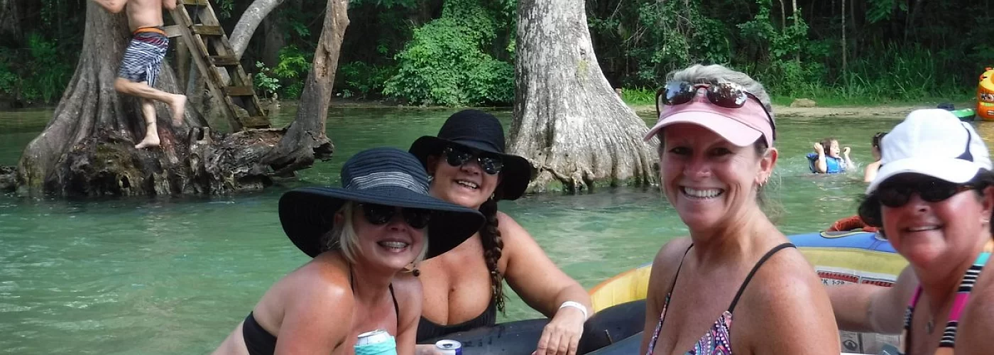 A group of women are sitting on a raft in the water.