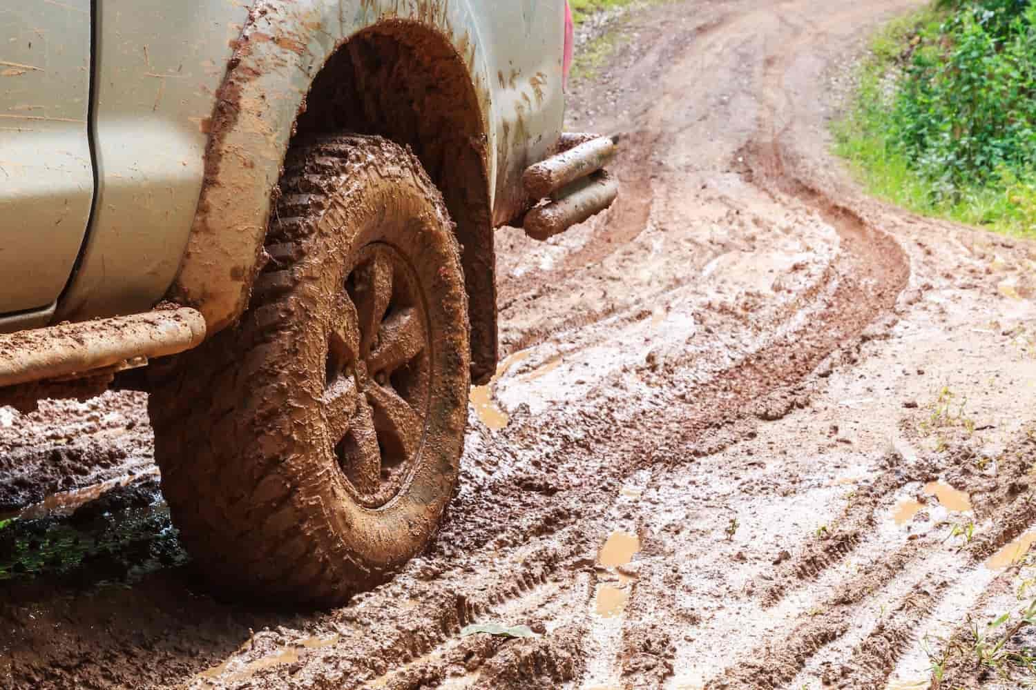 A Truck is Driving Down a Muddy Dirt Road — Fosters Ace Auto Repairs In Aitkenvale, QLD
