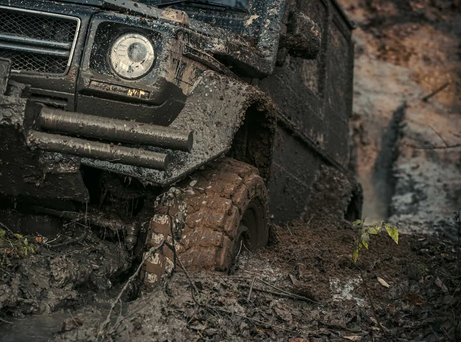 A Black Off Road Vehicle is Stuck in the Mud — Fosters Ace Auto Repairs In Aitkenvale, QLD