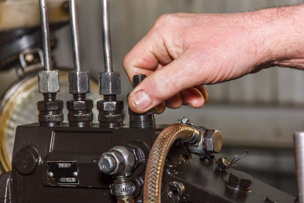 A Person is Working on a Machine With a Wrench — Fosters Ace Auto Repairs In Aitkenvale, QLD