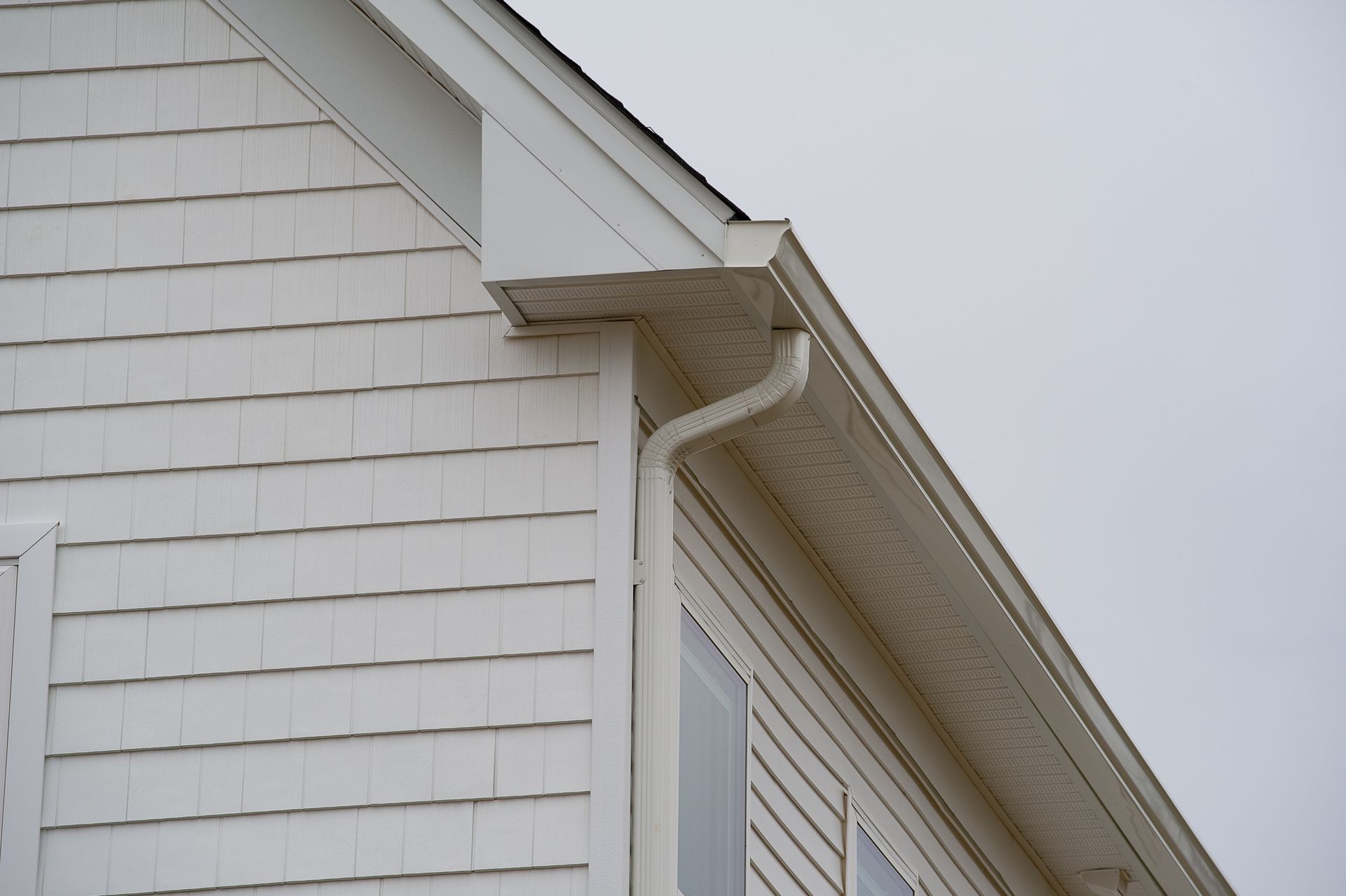 White house siding with a gutter and downspout. White house siding with a gutter and downspout.