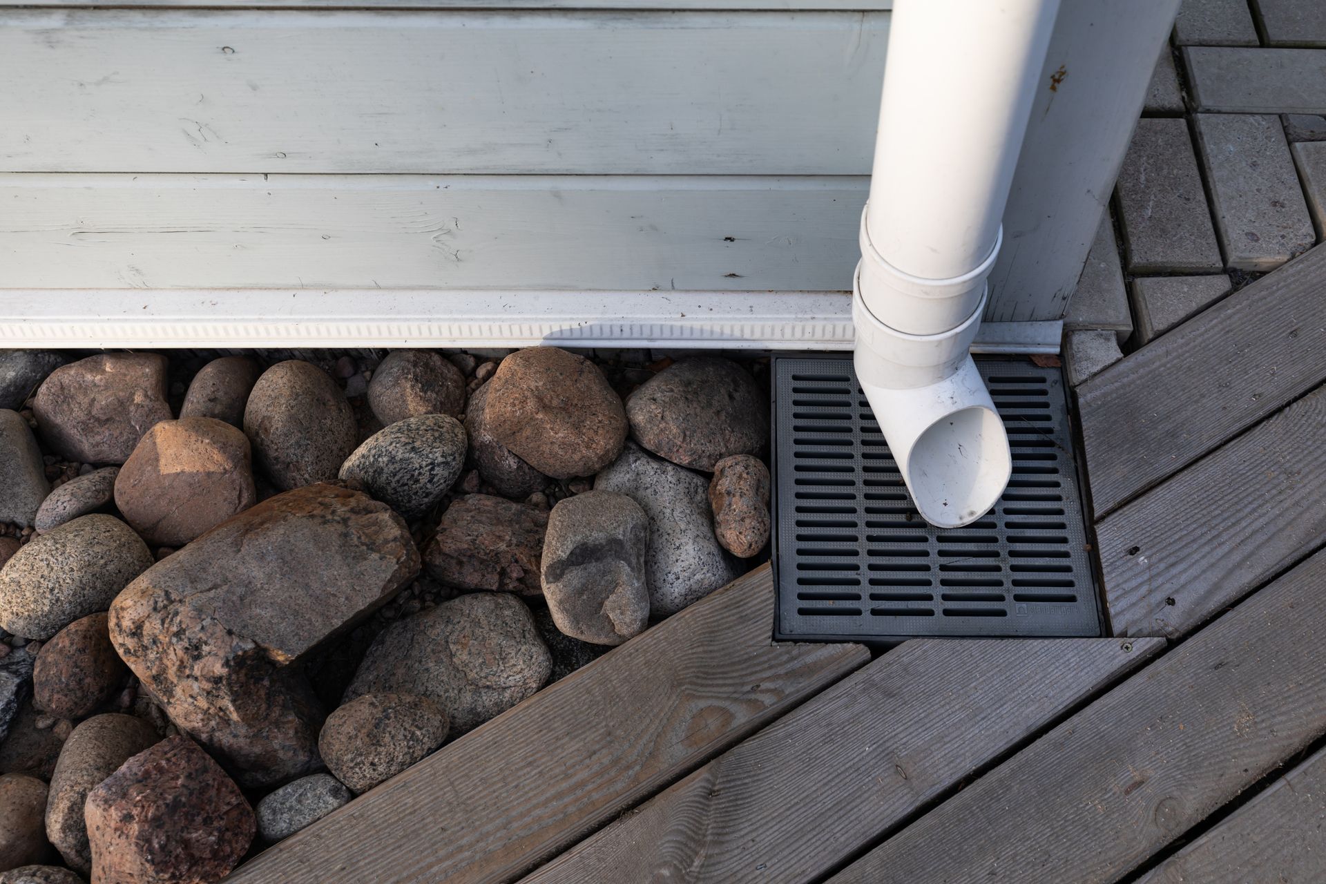 Person installing a rolled, black gutter guard on a dark roof gutter. Person installing a rolled, black gutter guard on a dark roof gutter.