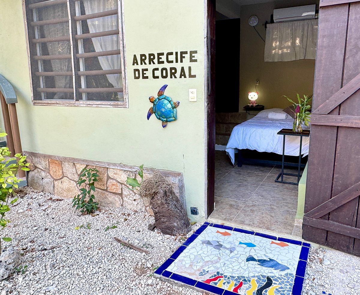 A hotel room with a bed and a sign that says arrecife de coral