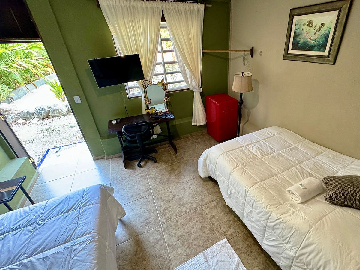 A hotel room with two beds , a desk and a television.