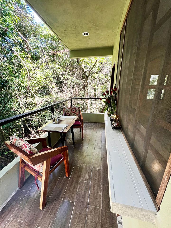 There is a balcony with a table and chairs on it.