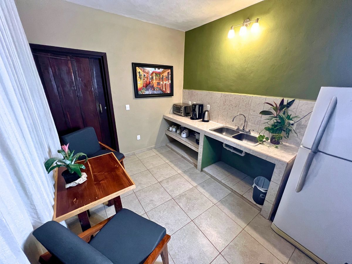 A kitchen with a table and chairs and a refrigerator.