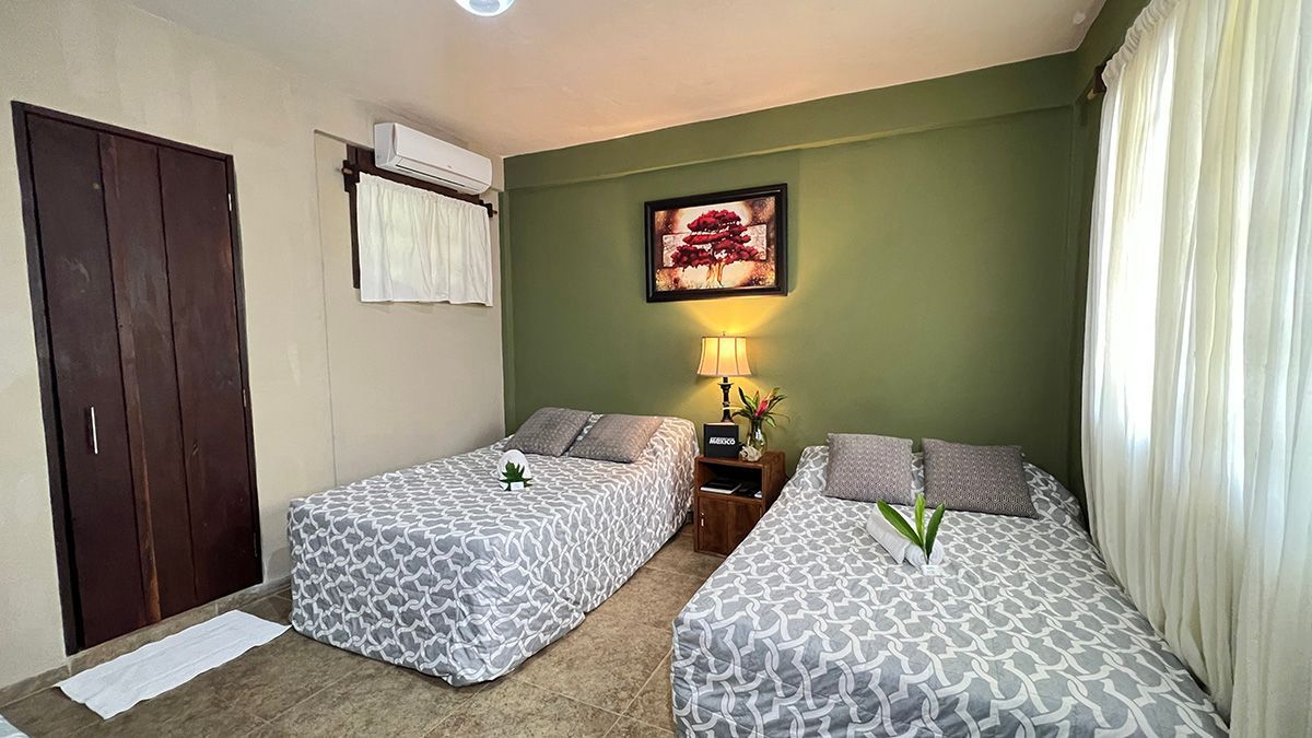 A hotel room with two beds and a picture on the wall.