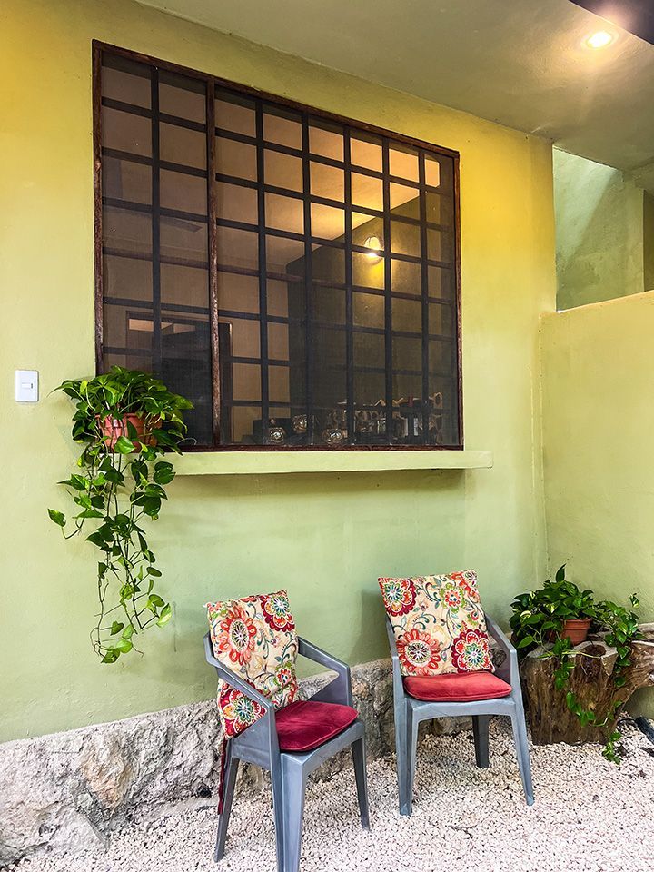Two chairs are sitting in front of a window on the side of a hotel room.