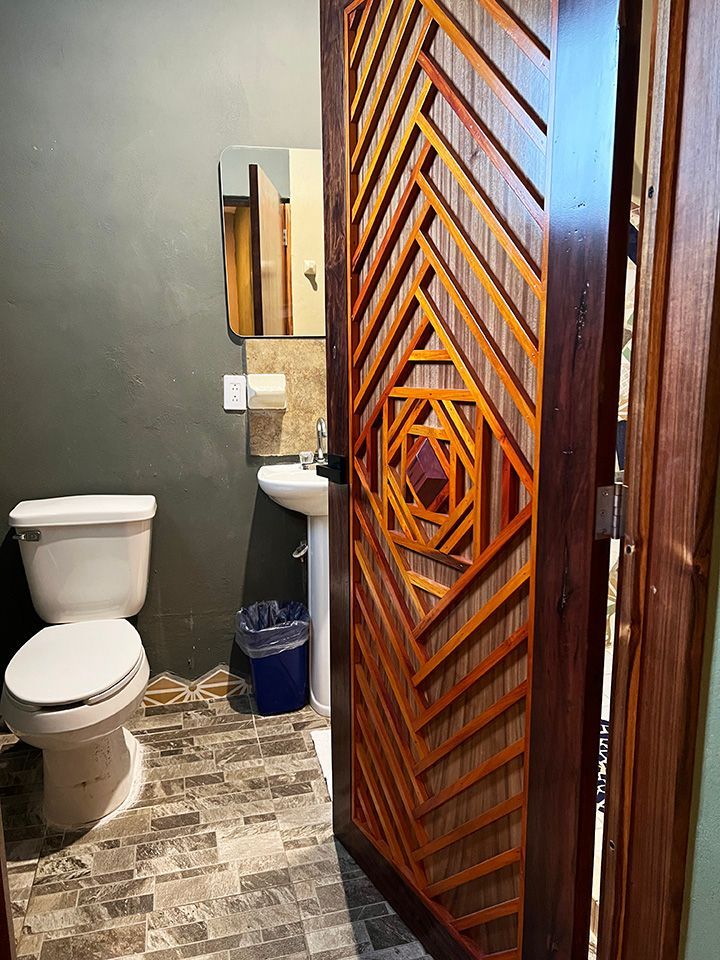 A bathroom with a toilet , sink and mirror.