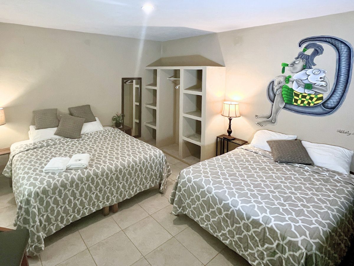 A hotel room with two beds and a painting on the wall.
