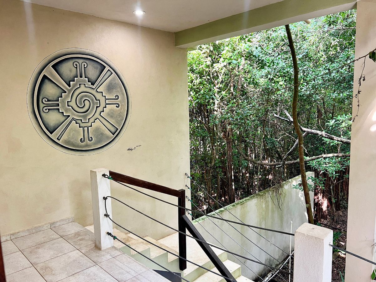 A staircase leading up to a balcony with a mural on the wall.