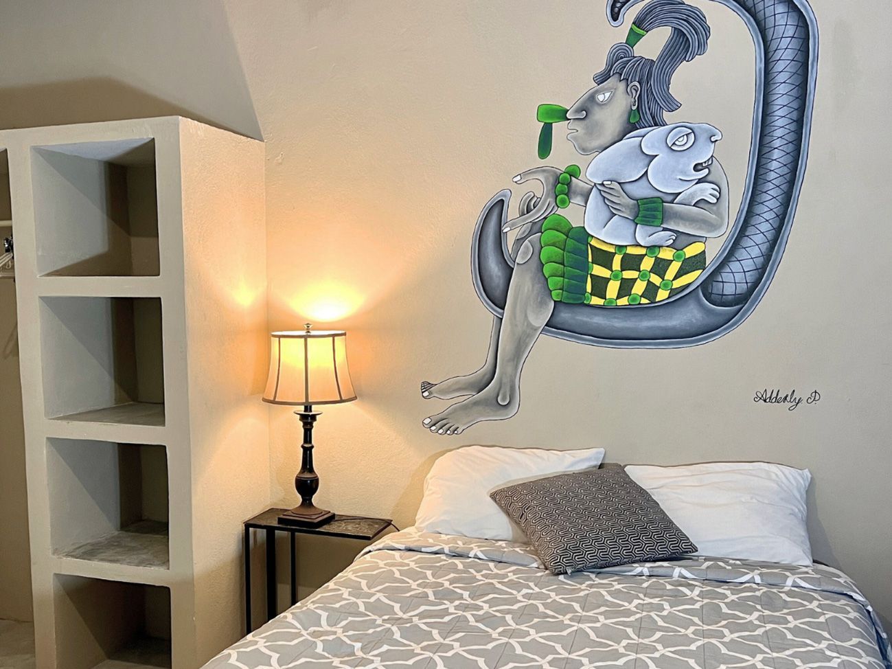 A hotel room with a bed and a painting on the wall