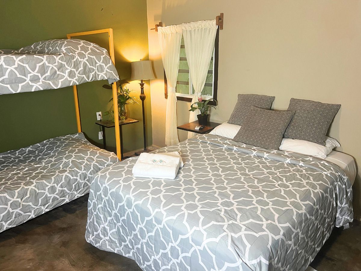 A hotel room with two beds and a bunk bed.