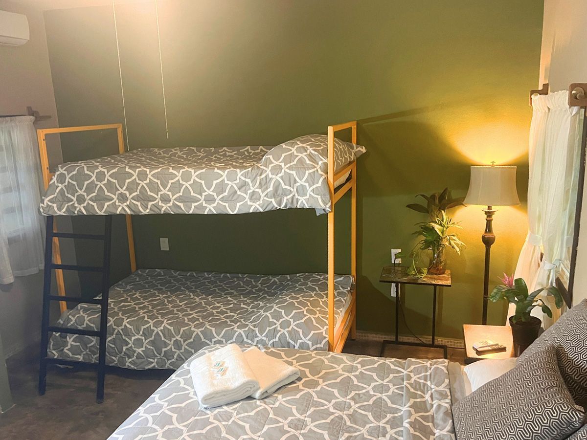 A hotel room with two bunk beds and a bed.