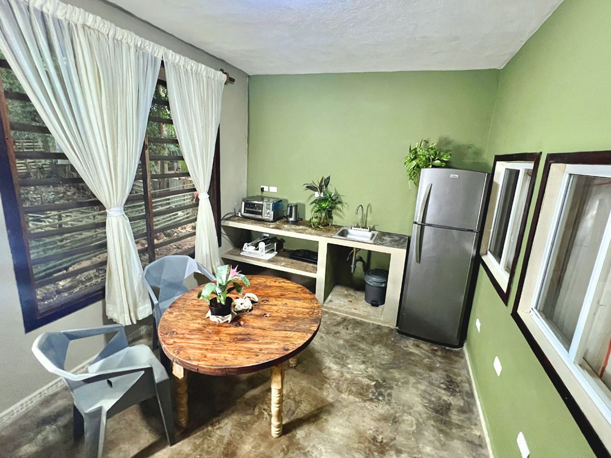 A kitchen with a table and chairs and a refrigerator.